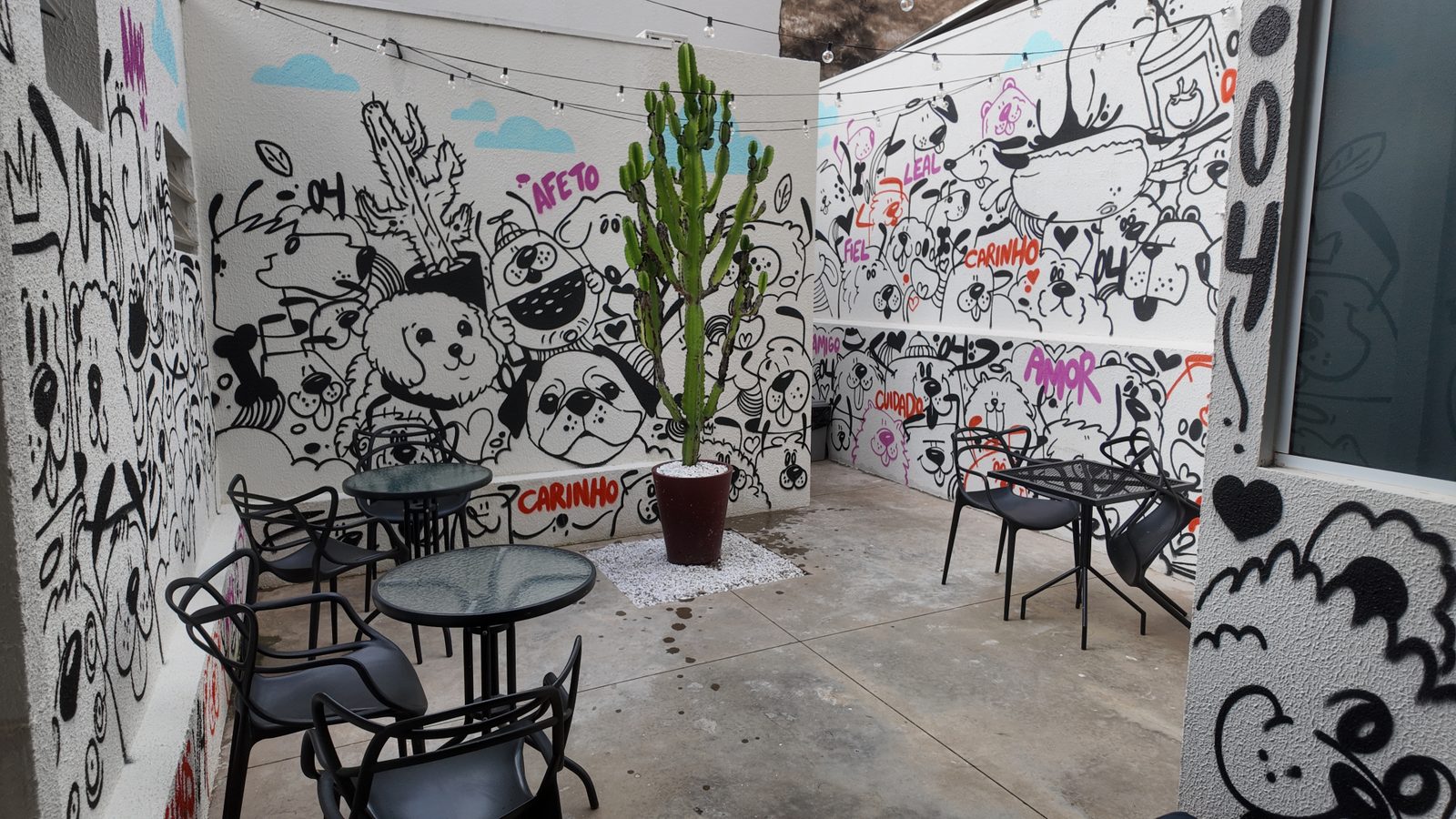 Espaço de espera do pet shop Clube04 com mural artístico de cães